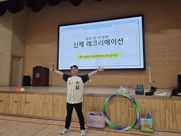 신체 레크리에이션 화면 앞에서 두 팔을 벌린 강진우 대표