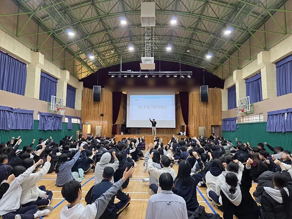 체육관을 가득 채운 학생들이 주먹을 들고 가위바위보 게임을 하는 모습