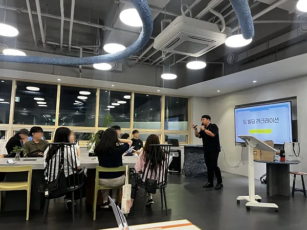 청소년센터 라운지에서 팀 빌딩 레크리에이션을 진행하는 모습
