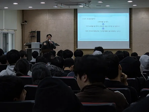 강당에서 학생들에게 스피치 강의를 하는 모습